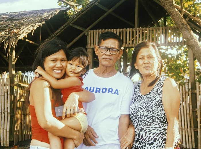 Three generations of a family smiling together outdoors